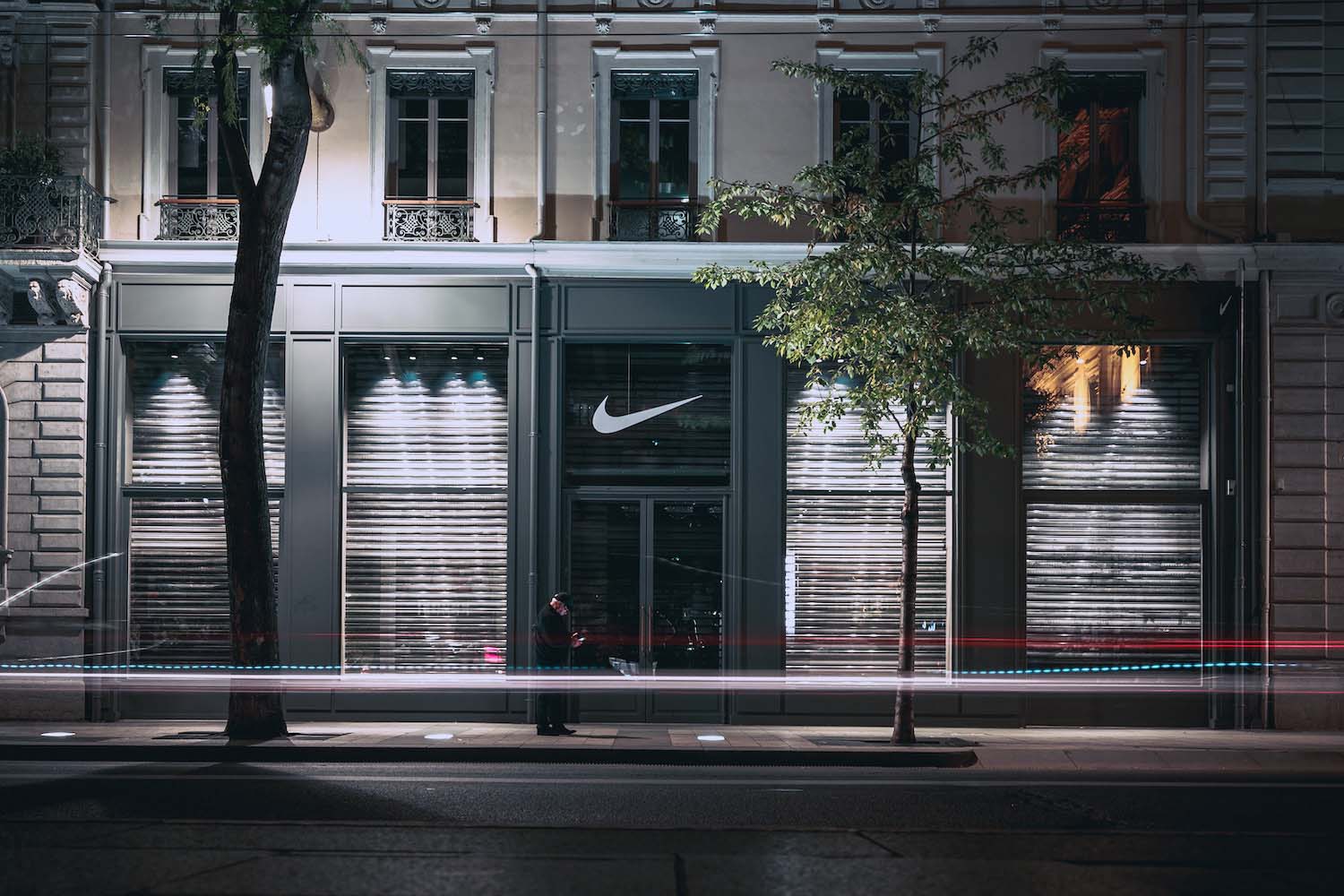 Nike store at night with illuminated signage – powerful example of brand visibility and trust through consistent brand presence.