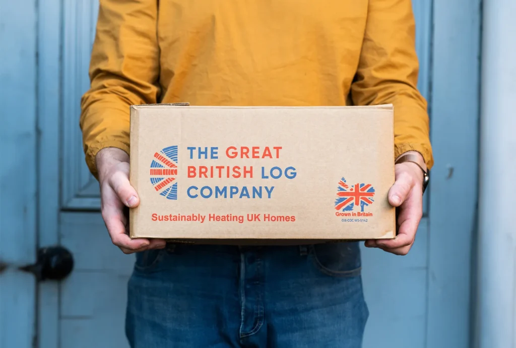 Printed logo on firewood delivery box held by a person wearing vibrant clothes – branded packaging design for Shropshire-based log business.