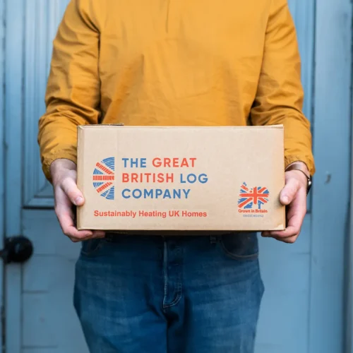 Printed logo on firewood delivery box held by a person wearing vibrant clothes – branded packaging design for Shropshire-based log business. Cropped square.