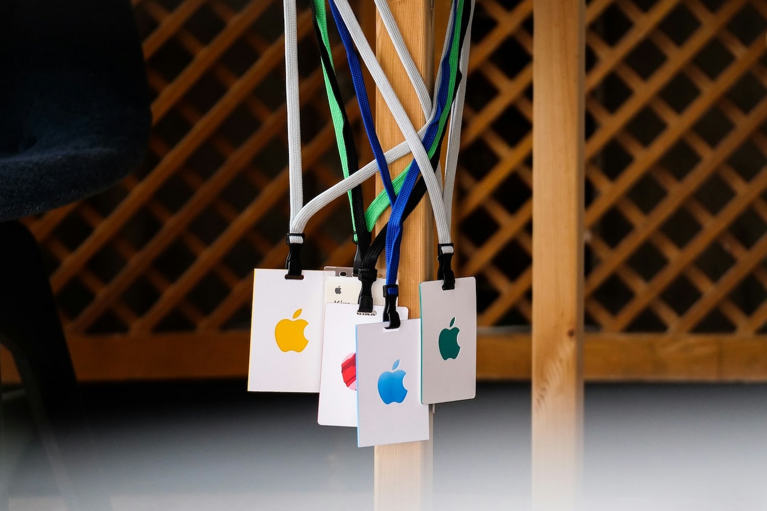 Multiple colourful Apple logos on lanyards hanging from a chair – iconic minimalist branding showcasing simplicity and global recognition in logo design.