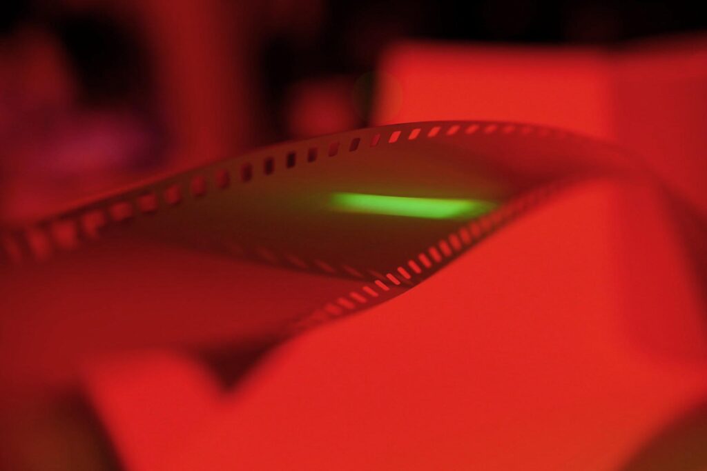 Artistic photo of camera film under red light – symbolic of trusting the creative development process in professional design.