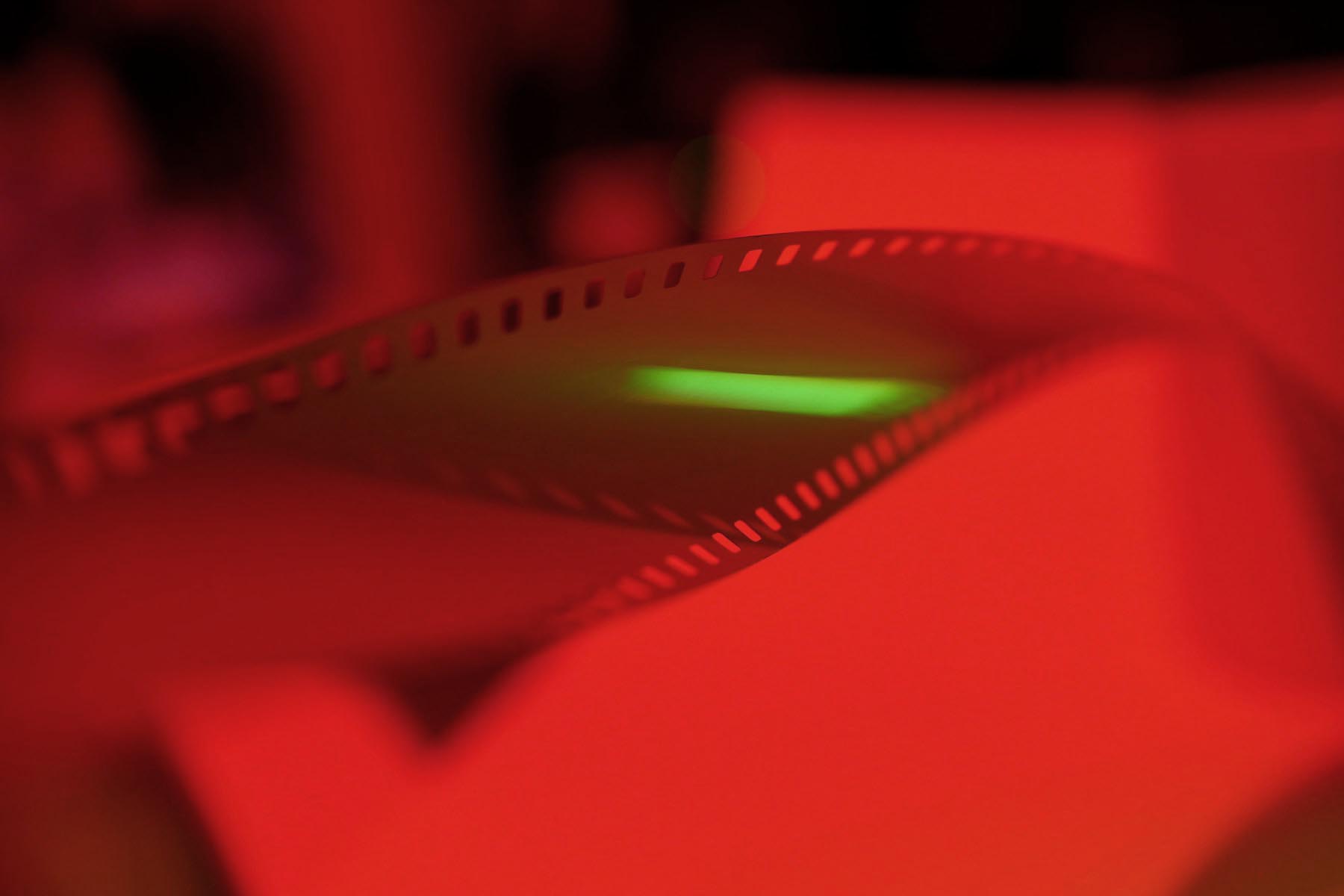 Artistic photo of camera film under red light – symbolic of trusting the creative development process in professional design.