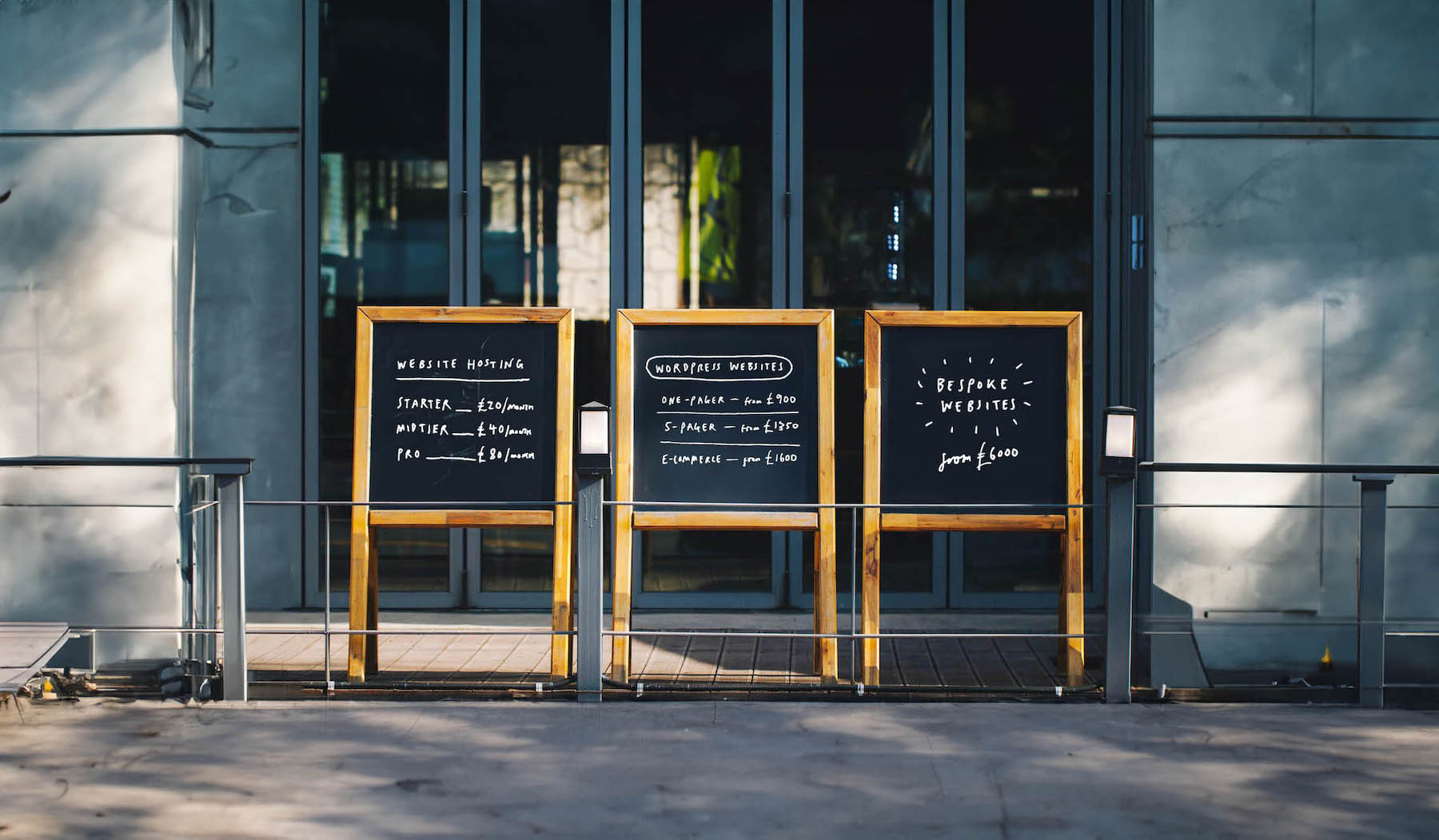 Artwork for web design article – chalkboards with website pricing on to highlight article content; “How much does a website in the UK really cost?”. Written by David Payne, a freelance graphic designer in Shrewsbury.