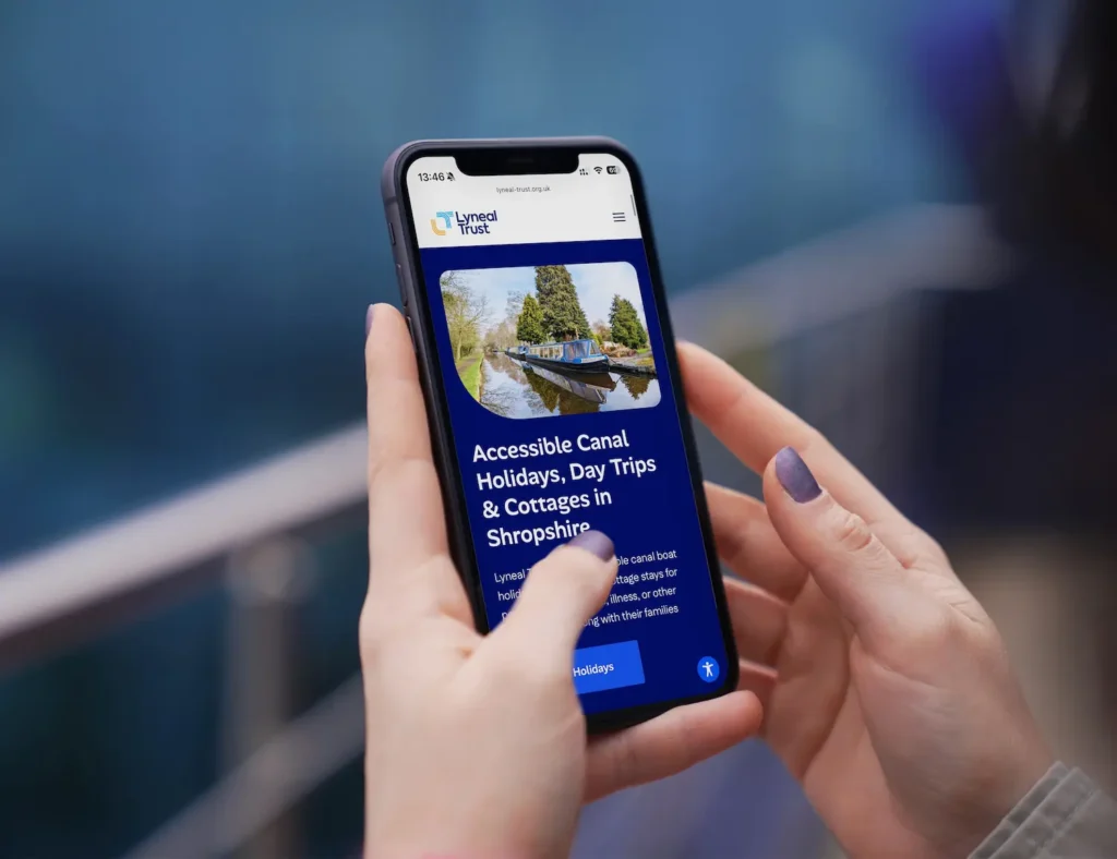 Woman holding iPhone displaying the Lyneal Trust accessible website design