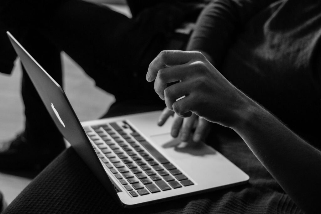 Close-up black and white photo of hands typing on a laptop, Studio Payne Shrewsbury design agency
